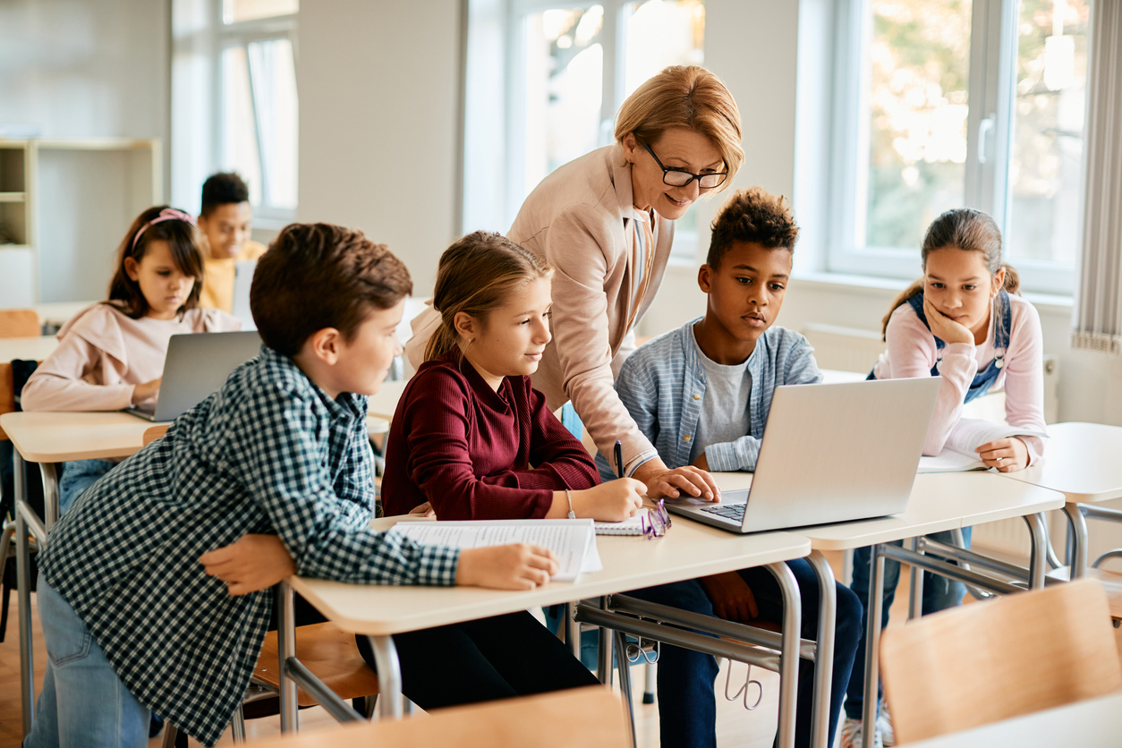 Students and a teacher working together in a bright classroom